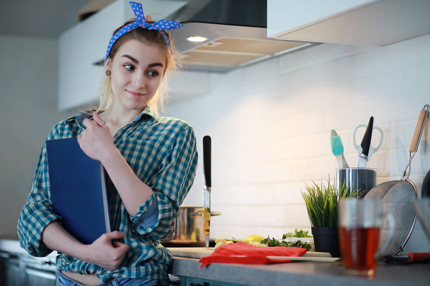 ein nettes junges Mädchen in der Küche bereitet Essen zu - Foto, Bild