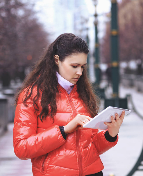 junge Frau mit digitalem Tablet auf Stadthintergrund - Foto, Bild