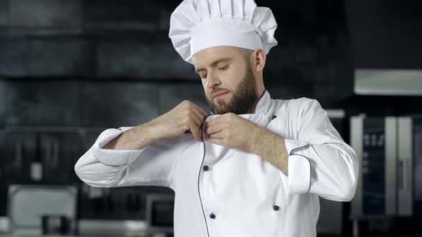 Šéfkuchař se připravuje na vaření v kuchyni. Portrét seriózní mužské kuchařky. - Záběry, video