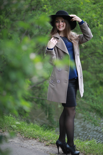 Fiatal lány, egy kabát, egy tavaszi parkban - Fotó, kép
