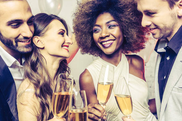Uomini e donne che festeggiano mentre tintinnano bicchieri con spumante
 - Foto, immagini