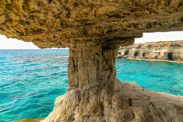 Το ασυνήθιστο γραφικό σπήλαιο βρίσκεται στις ακτές της Μεσογείου. Κύπρος, Αγία Νάπα. - Φωτογραφία, εικόνα