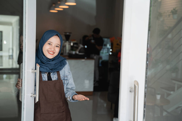 friendly asian beautiful muslim woman welcoming guest to the shop - Zdjęcie, obraz