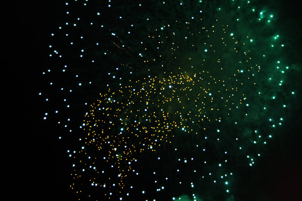 A poeira de estrela de luzes de fogos de artifício amarelas e verdes brilhantes durante o Halloween, Natal, Dia da Independência, Ano Novo
. - Foto, Imagem