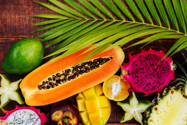 Tropical fruit on dark wooden background - Foto, Imagen