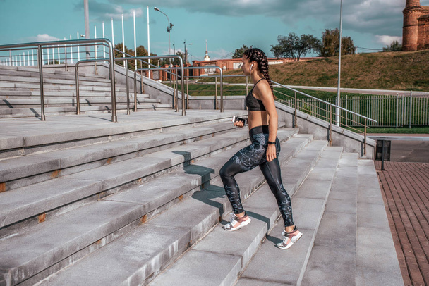 Girl athlete, goes steps, walk free space, fitness workout, summer in city, day and morning. Sportswear, smartphone, headphones. Active lifestyle, motivation power. Internet application, music. - Fotografie, Obrázek