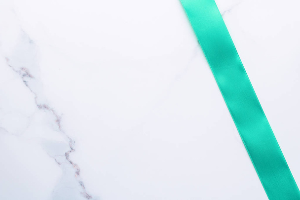 Πράσινη μεταξωτή κορδέλα σε μαρμάρινη φόντο, κορυφή θέα - Φωτογραφία, εικόνα