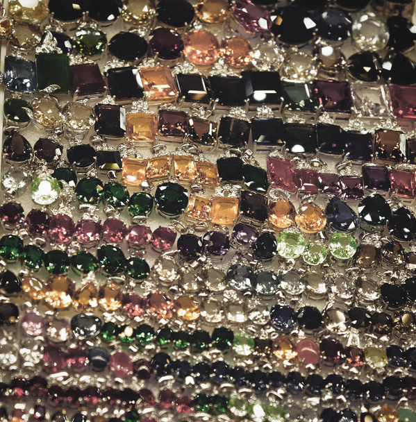 γυναικεία δαχτυλίδια με πολύτιμες πέτρες, κοσμήματα γυναικών, ένα μεγάλο αριθμό κοσμημάτων, φόντο - Φωτογραφία, εικόνα