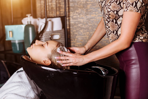 Beautiful woman washing hair in a hair salon - Foto, immagini