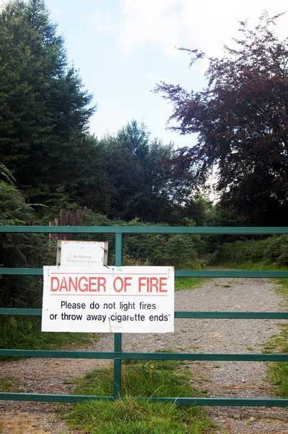 Warning sign on metal gate in woodland - Fotoğraf, Görsel