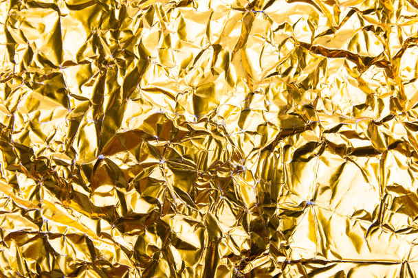 Goud verfrommeld folie papier textuur achtergrond. - Foto, afbeelding
