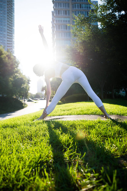 Woman doing yoga in a park - Valokuva, kuva