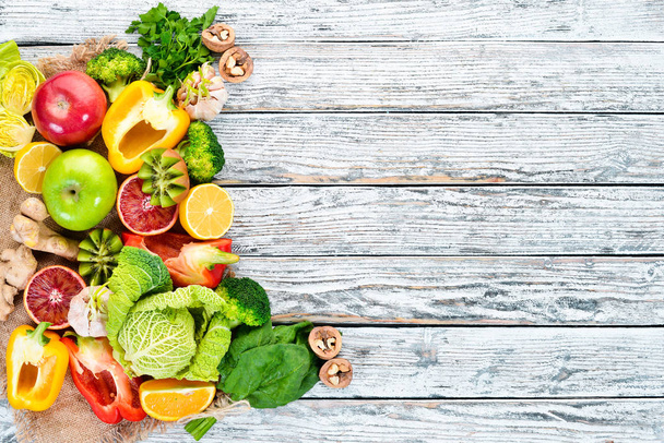 Healthy vegetarian food: Orange, lemon, apple, rose, garlic, broccoli, apple, kiwi, spinach. Top view. free space for your text. - Foto, Bild