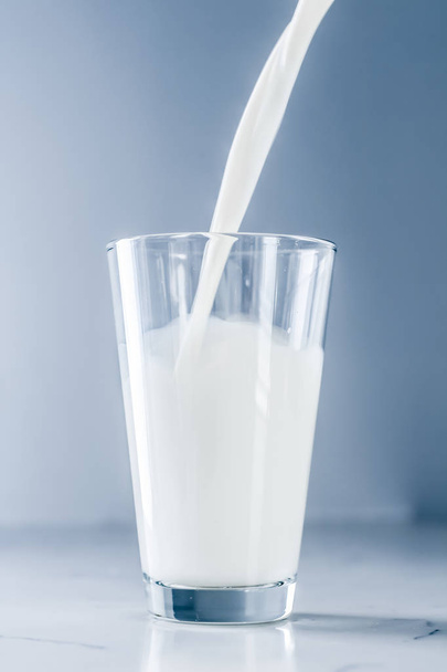Giornata Mondiale del Latte, versando in vetro sul tavolo di marmo
 - Foto, immagini