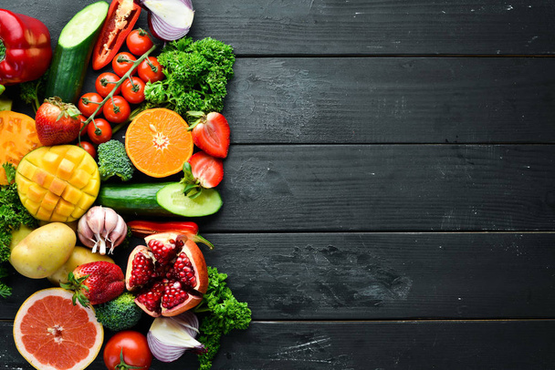 Frutas, verduras y bayas frescas. Sobre un fondo negro. Banner Vista superior. Espacio libre para tu texto
. - Foto, Imagen