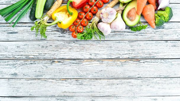 Fresh vegetables. Avocado, cucumber, onion, garlic, tomatoes, carrots, horseradish. Top view. Free space for your text. - Φωτογραφία, εικόνα