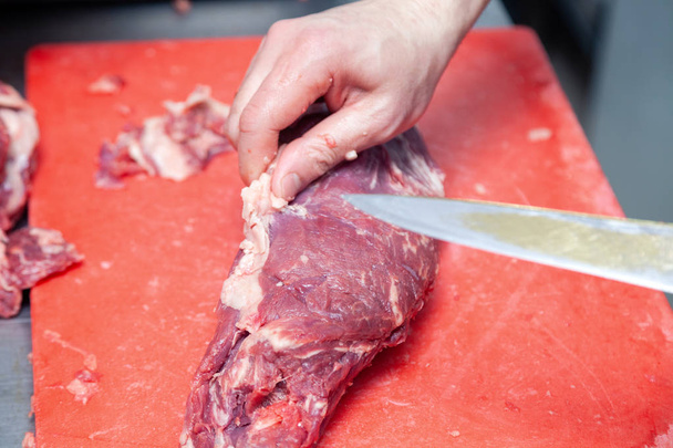 Closeup caucasian man chef butcher hands cutting piece of fillet - Photo, Image
