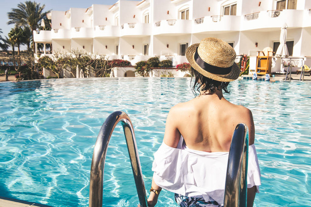 Frau mit Hut und modischem Badeanzug am Pool - Foto, Bild