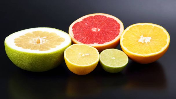 Citrusfélék. Vágott narancs, citrom, lime és a grapefruit a sötét Bac - Fotó, kép