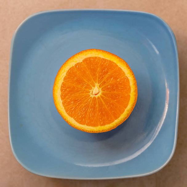 Meia tangerina ou mandarina numa placa azul. Fechar e textura com as polpas uma laranja. Um conceito para comida saudável. Vista superior. Foco suave
. - Foto, Imagem
