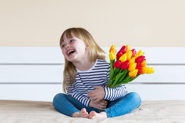 Little girl with colorful tulip flowers - Foto, afbeelding