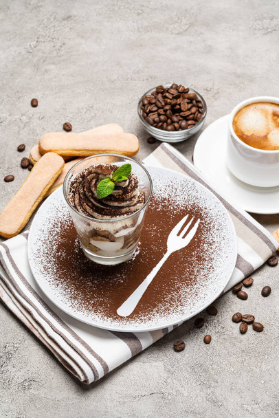 Classic tiramisu dessert in a glass and cup of coffee on concrete background - Foto, Imagem