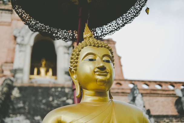 Estatua de Buda de oro en color gris
. - Foto, imagen