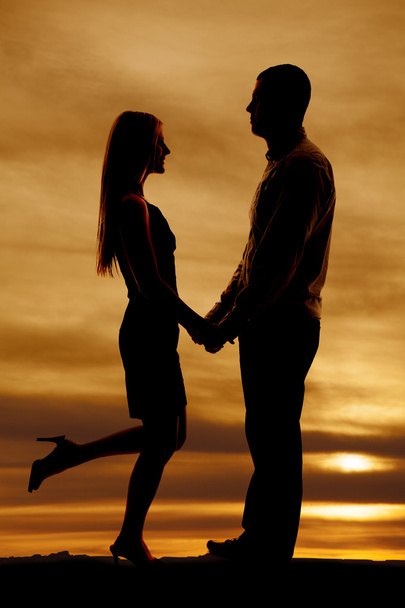 silhouette couple stand together her leg up - Valokuva, kuva
