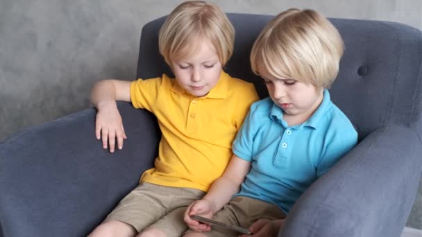 Irmãos estão assistindo ou jogando ou aprendendo algo em um smartphone
 - Filmagem, Vídeo