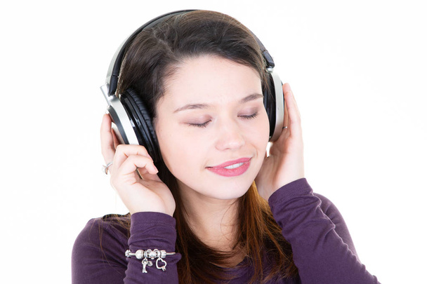 Model young trendy beautiful girl with natural make-up with headphones closed eyes on white background - Фото, зображення