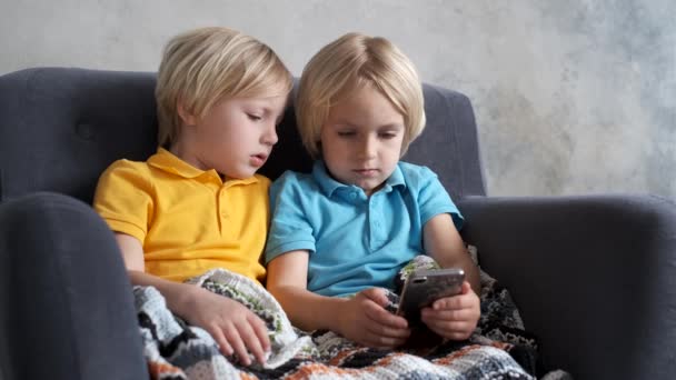 Irmãos estão assistindo ou jogando ou aprendendo algo em um smartphone
 - Filmagem, Vídeo