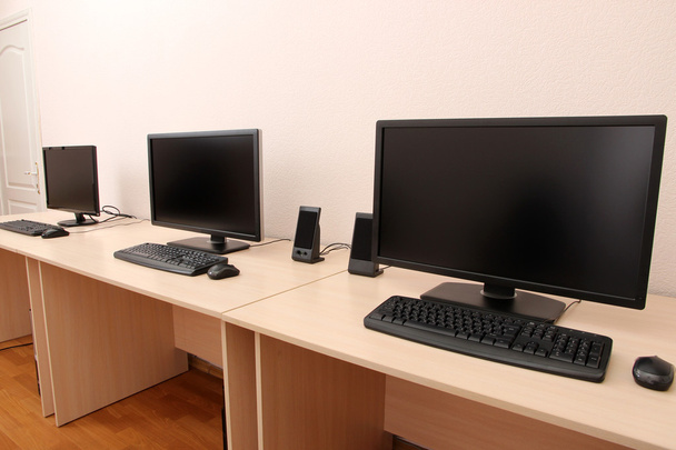 Комп'ютери на столиках в кімнаті
 - Фото, зображення