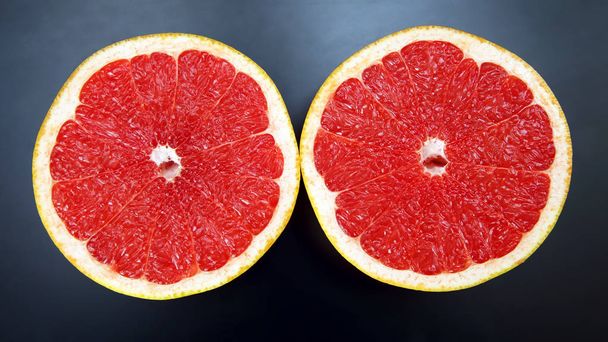 Citrus fruit. Sliced grapefruit on a dark background - Photo, Image