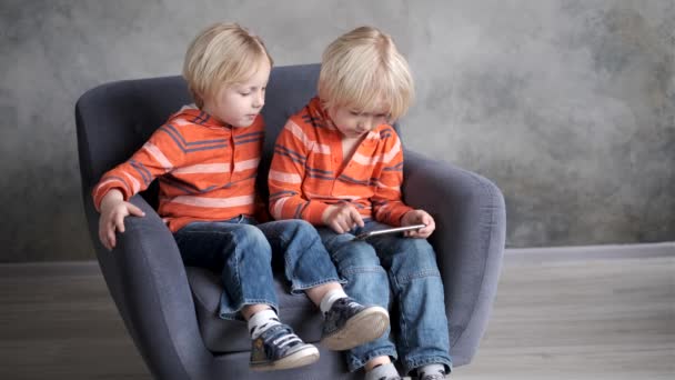 Bratři se dívají, hrají nebo se učí něco v chytrém telefonu - Záběry, video