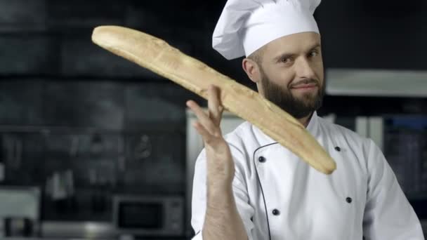 Koch macht Spaß mit französischem Brot in der Küche. Nahaufnahme Mann Hände spielen mit Brot. - Filmmaterial, Video