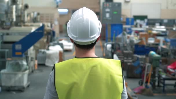 Εργαζόμενος εργοστάσιο με ασφάλεια σκληρό καπέλο περπάτημα μέσα από βιομηχανικές εγκαταστάσεις - Πλάνα, βίντεο