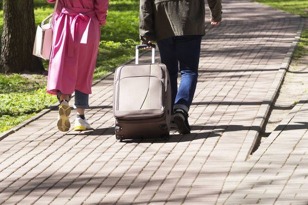 Le concept de voyage. Les touristes avec une grande valise traversent la ville
. - Photo, image