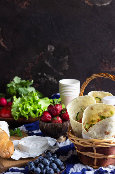 Fresh tortilla wraps with roasted chicken and vegetables, fresh juices, various vegetables and berries, fresh baguette and cheese. Ideas for picnic. - Фото, изображение
