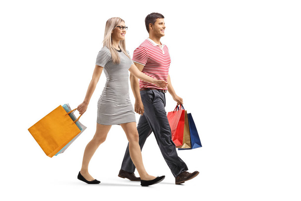 Young man and woman walking with shopping bags  - Foto, Bild