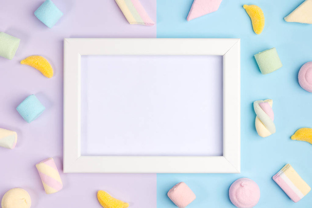 Frame for a photo on the background of sweets. Marshmallows on pink and blue backgrounds. Top view. - Foto, Imagen