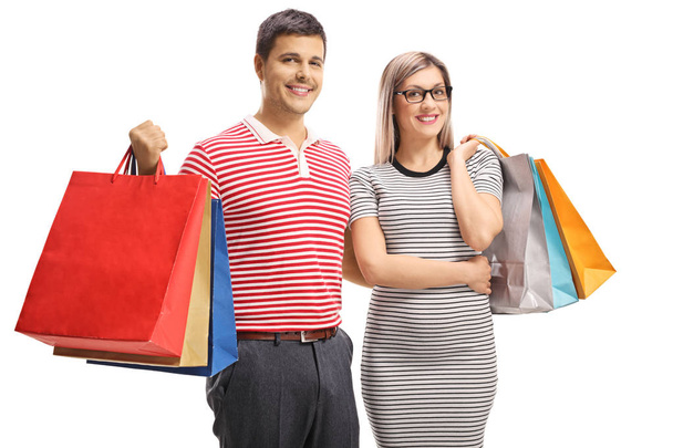 Portrait of a cheerful young couple posing with shopping bags - Фото, зображення