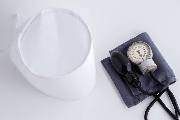 casquette médicale et tonomètre sur fond blanc isolé. vue de dessus
 - Photo, image