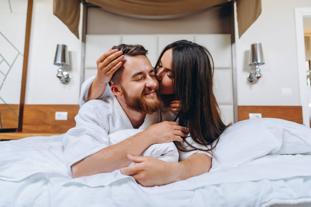 Immagine che mostra una coppia felice che riposa in camera d'albergo
 - Foto, immagini