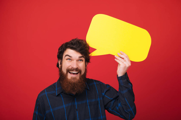 Фотографія мрійливого бородатого чоловіка, що тримає міхурну промову на червоному тлі
  - Фото, зображення
