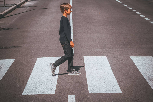 Kind überquert Fußgängerüberweg in der Stadt - Foto, Bild