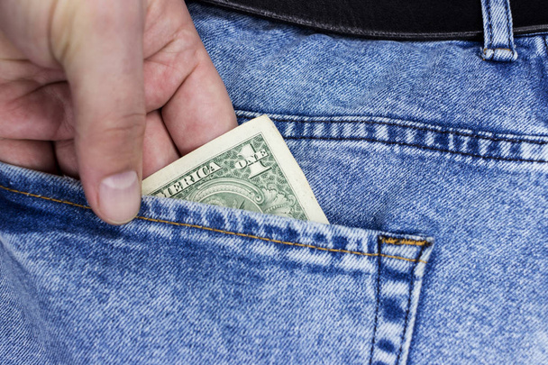 US dollars are visible in the pocket. 100 dollar bills sticking out of a jeans denim pocket. One hundred dollar bills. Money in your pocket. Business concept exchange. Wealth in pants.Good luck smile. - Photo, Image