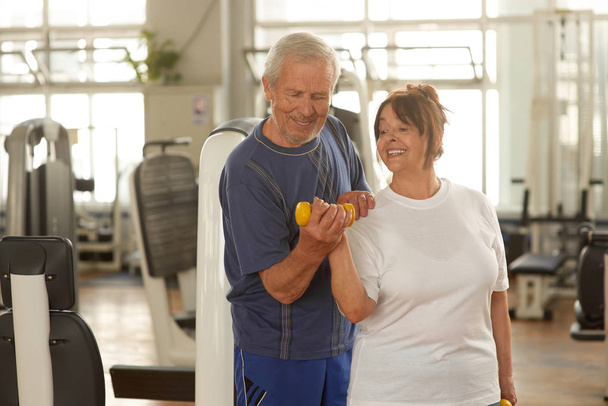 Senior woman lifting weights with her husband. - Photo, Image