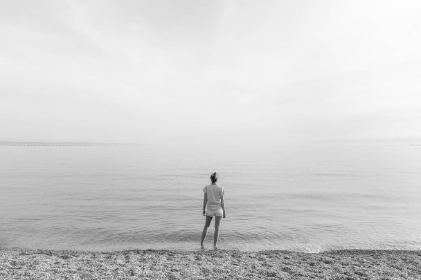 Szczęśliwy człowiek beztroski ciesząc się zachód słońca spaceru na plaży Pabbled biały. - Zdjęcie, obraz