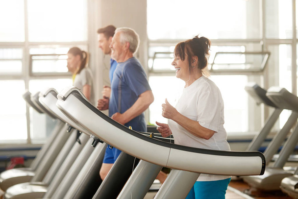 Mature caucasian woman running on treadmill. - Photo, Image