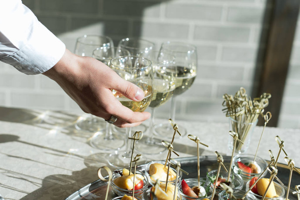 glasses of champagne on the table with a white tablecloth. Celebration and party concept. The buffet table in the sun - Photo, Image